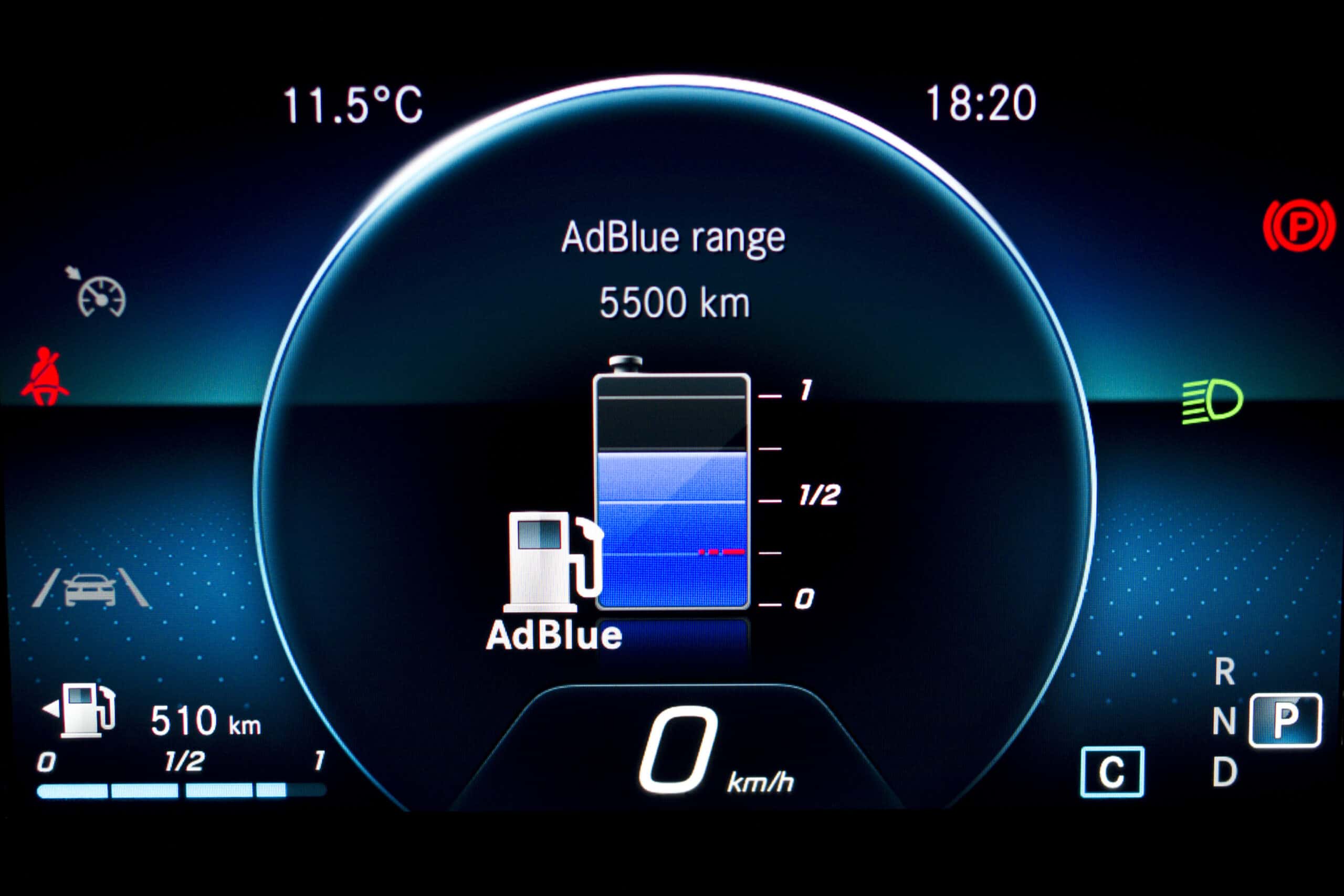 Close up of AdBlue level indicator on illuminated car dashboard. Car instrument panel with speedometer, fuel gauge and seat belt reminder. Urea level display on car cluster. Check diesel exhaust fluid